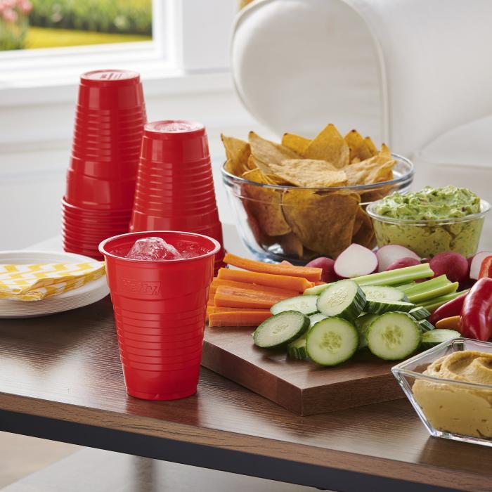 Hefty ECOSAVE Compostable Party Cup sitting on a wood table surrounded by snacks