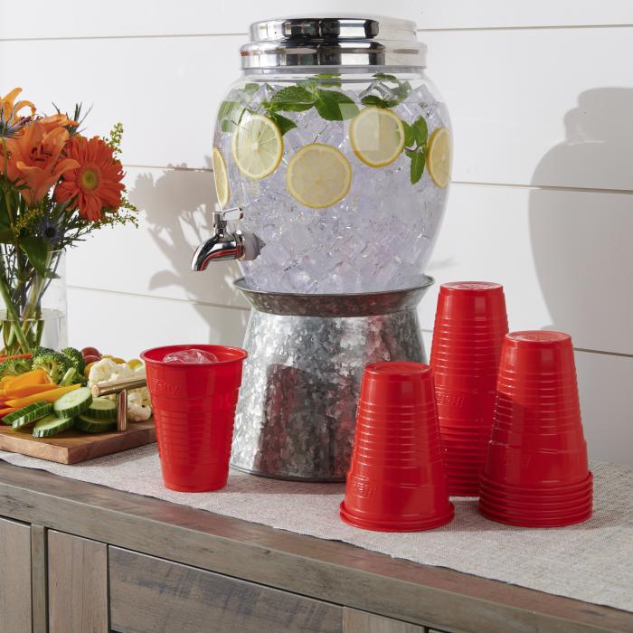Hefty ECOSAVE Compostable Party Cups sitting next to a drink dispenser filled with water