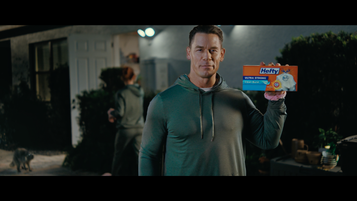 John Cena holding a package of trash bags
