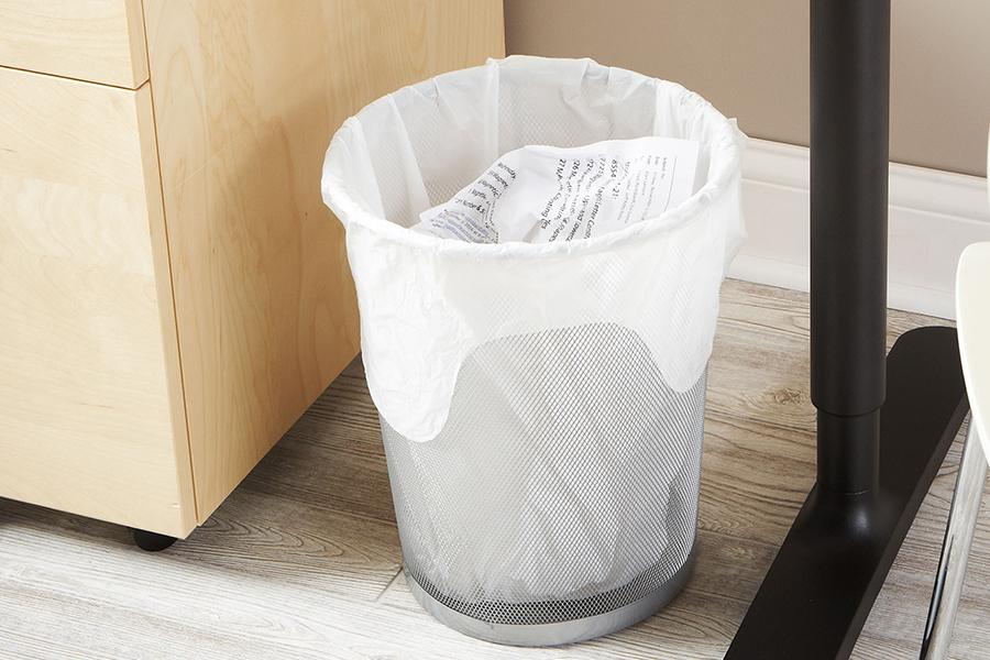 Small trash bag in a wire trash can.