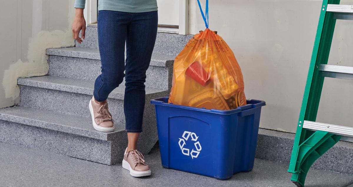 Woman placing ReNew bag into recycling bin