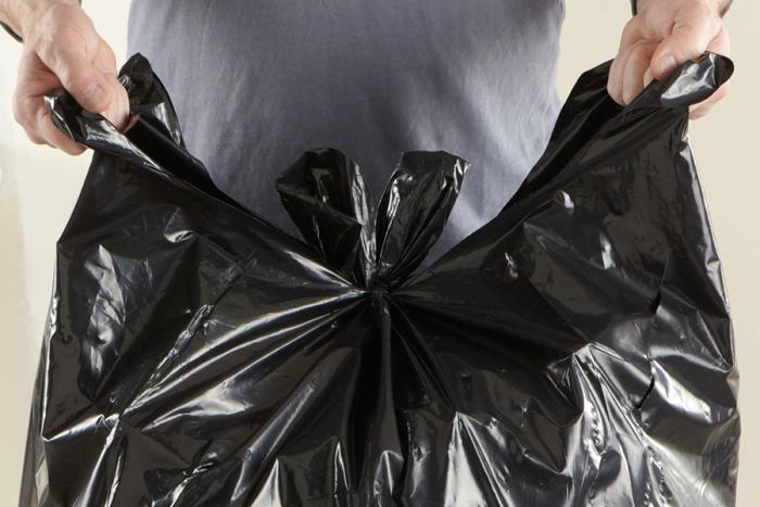 Person tying up a load and carry contractor bag.