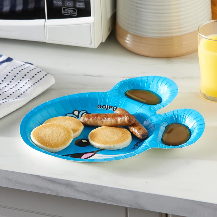 Pancakes, sausage and syrup sitting on a whale shaped Zoo Pals plate next to a microwave