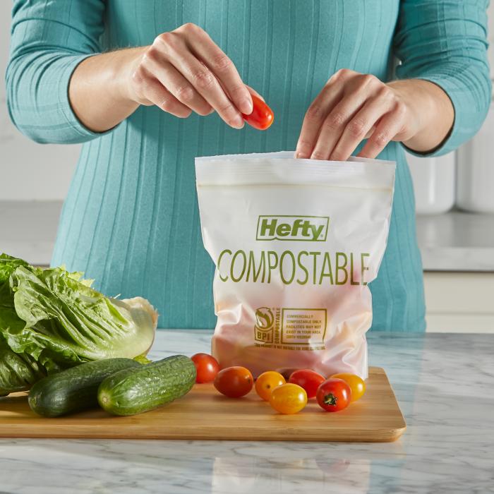 Person putting a tomato into a quart sized Hefty Compostable Press to Close Storage Bags