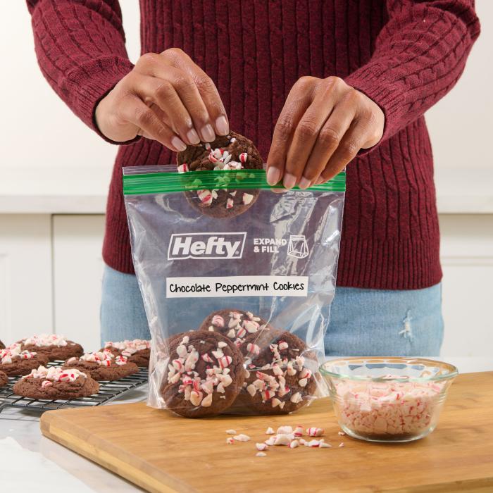 Person placing holiday cookies into a Hefty press to close sandwich bag