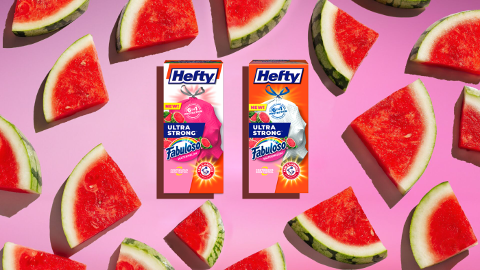 Hefty Ultra Strong Fabuloso Watermelon Trash Bag packages on a pink background with watermelon slices