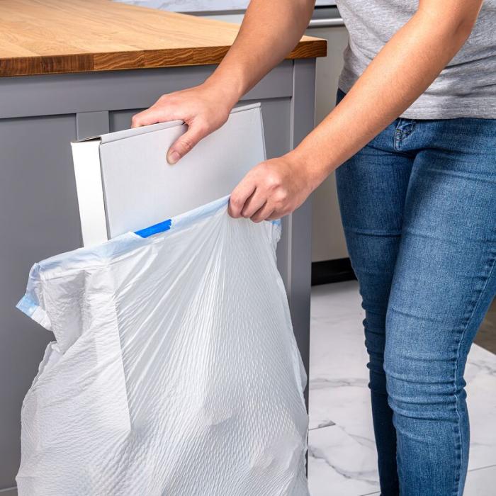 Person putting a large pizza box in a Hefty Ultra Strong Tall Kitchen Trash Bag