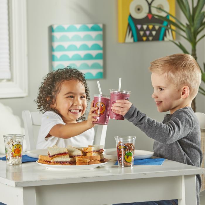 Two kids sitting at a table having a snack and fruit smoothie in a Zoo Pals Cup