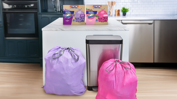 Hefty Ultra Strong Color Series pink and purple trash bags sitting in a kitchen