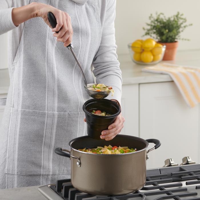 Person filling a Hefty Multi-Purpose Cup with chicken noodle soup