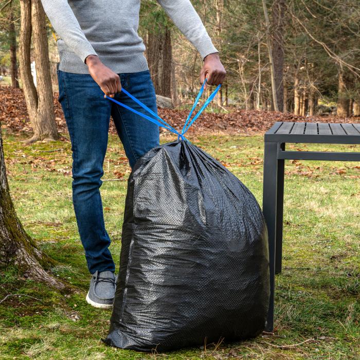 person tying the drawstring on a 39 gallon Hefty Ultra Strong Lawn and Leaf Bag
